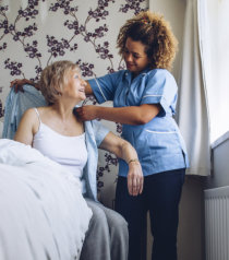 nurse dressing an elderly