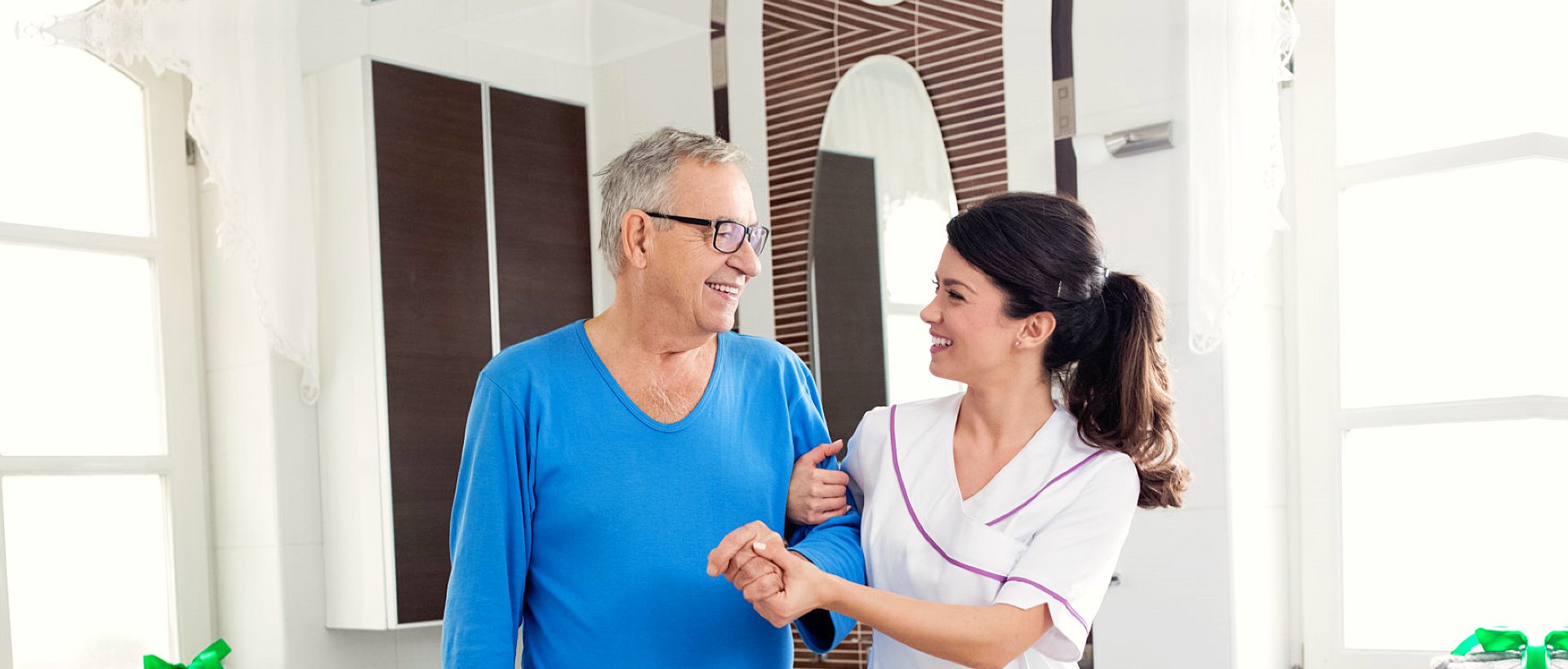 nurse supporting an elder man