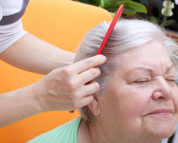 nurse combing an elderly's hair